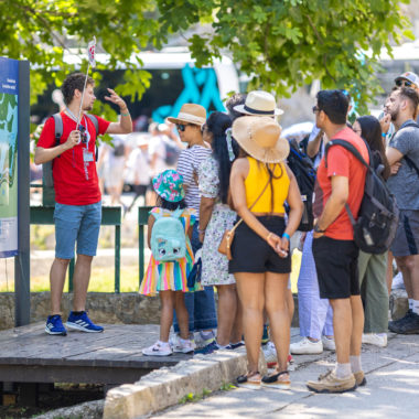 Group of excited tourists receiving a briefing at the entrance of the mesmerizing Krka Waterfalls