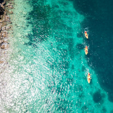 Aerial view of sea kayakers paddling along the stunning coastline