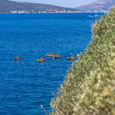 Colorful sea kayaks sail nearby Čiovo Island.