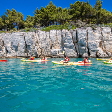 Sea kayakers navigating close to towering cliffs in Split