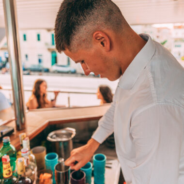 Barman serving drinks on a sunset cruise bar setting