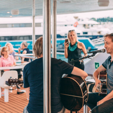 Musicians performing for guests during a scenic sunset cruise