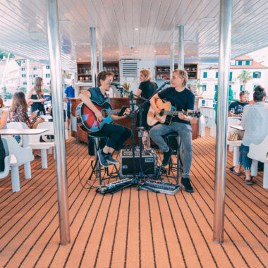 Musicians playing and guests enjoy the start of a sunset cruise