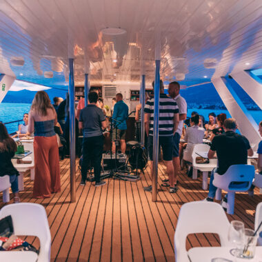 Guests enjoying the view from the sun deck during a sunset cruise departing from Split